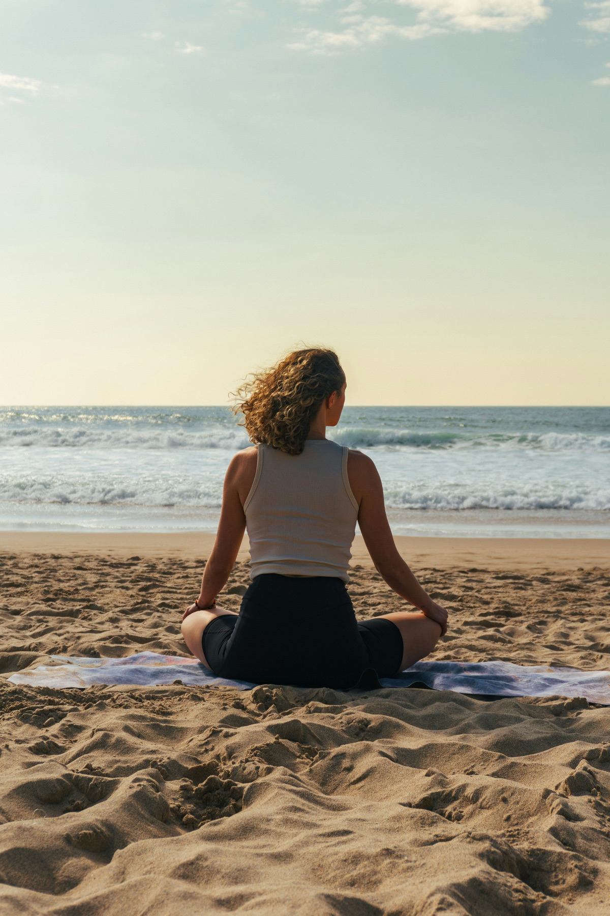Person sitzt ruhig am Meer
